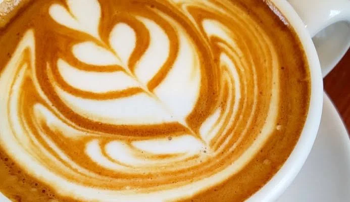 葉の形のラテアートが描かれたカフェラテ